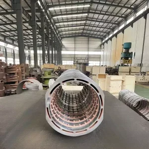 Factory photo: A large metallic motor press ring casting, high speed rail castings, silver-white in color with a smooth surface, set against the backdrop of a busy production workshop.