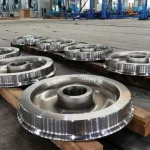 Railway wheels displayed in the factory with machining and inspection equipment in the background