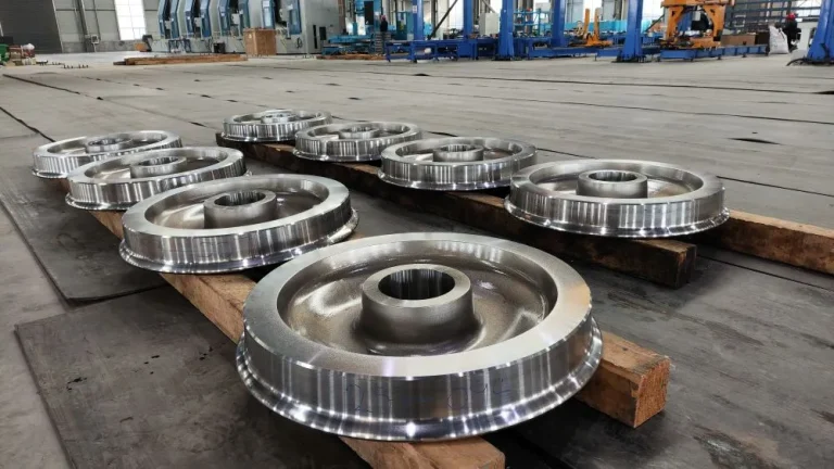 Railway wheels displayed in the factory with machining and inspection equipment in the background