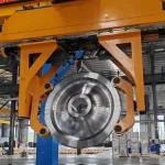 Gantry-robot løfter et jernbanehjul inde i et produktionsværksted