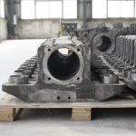 Large steel railway locomotive axle box steel castings, partially machined, unpainted, neatly lined up in the workshop